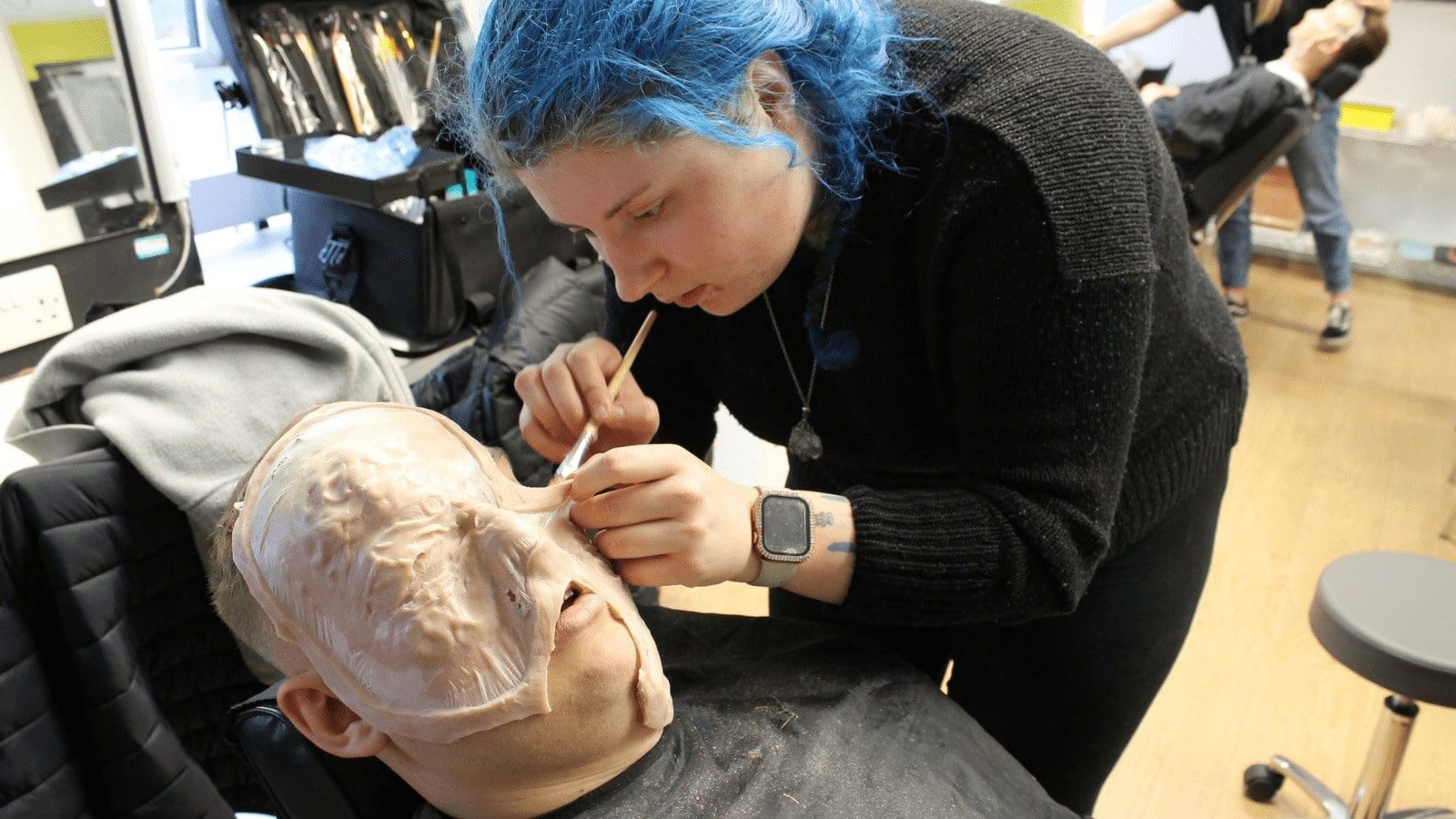 A Special Effects student working on the face of a willing volunteer.