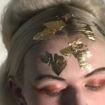 The top half of a BNU hair and make-up students face, covered in gold leaves