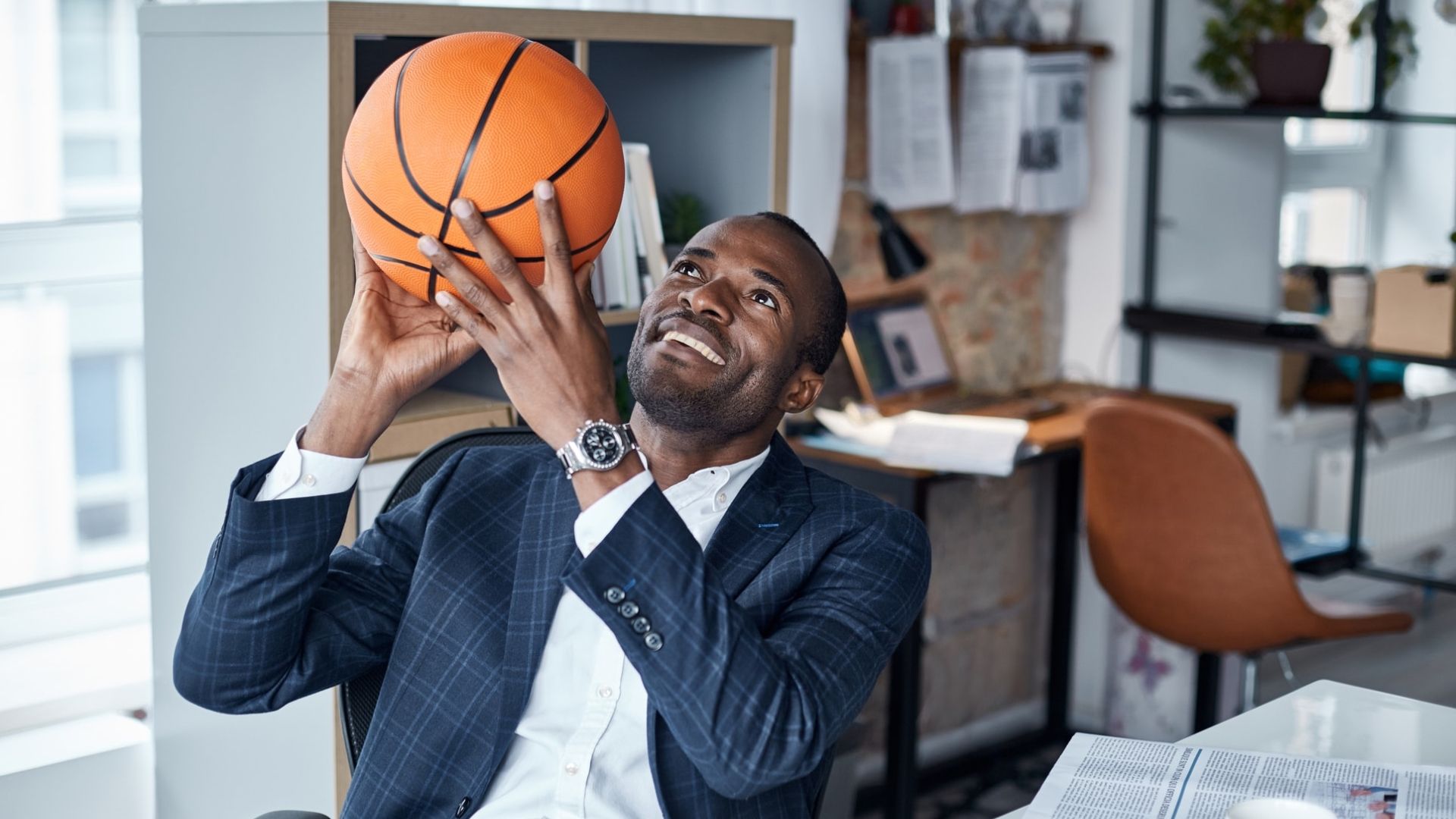 Male at desktop holding basketball ball