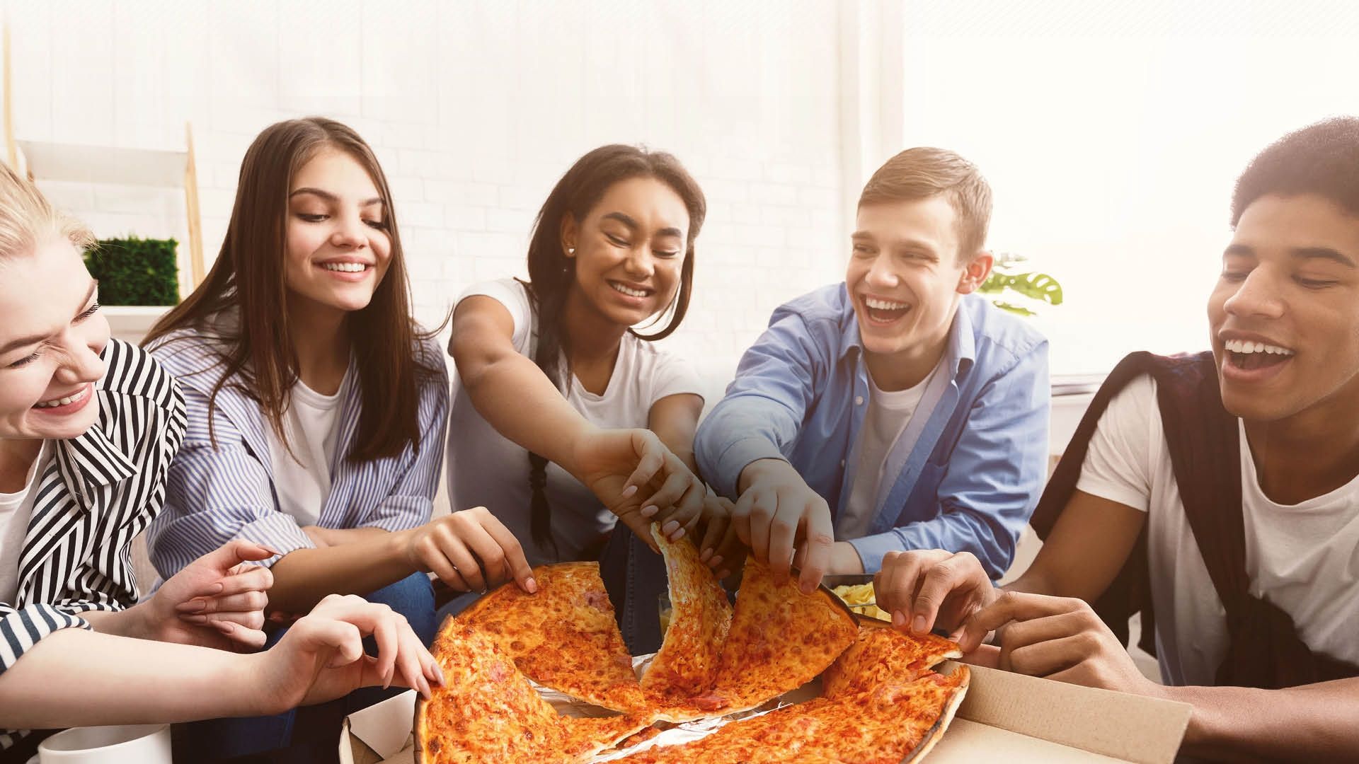 students sat round enjoying a pizza