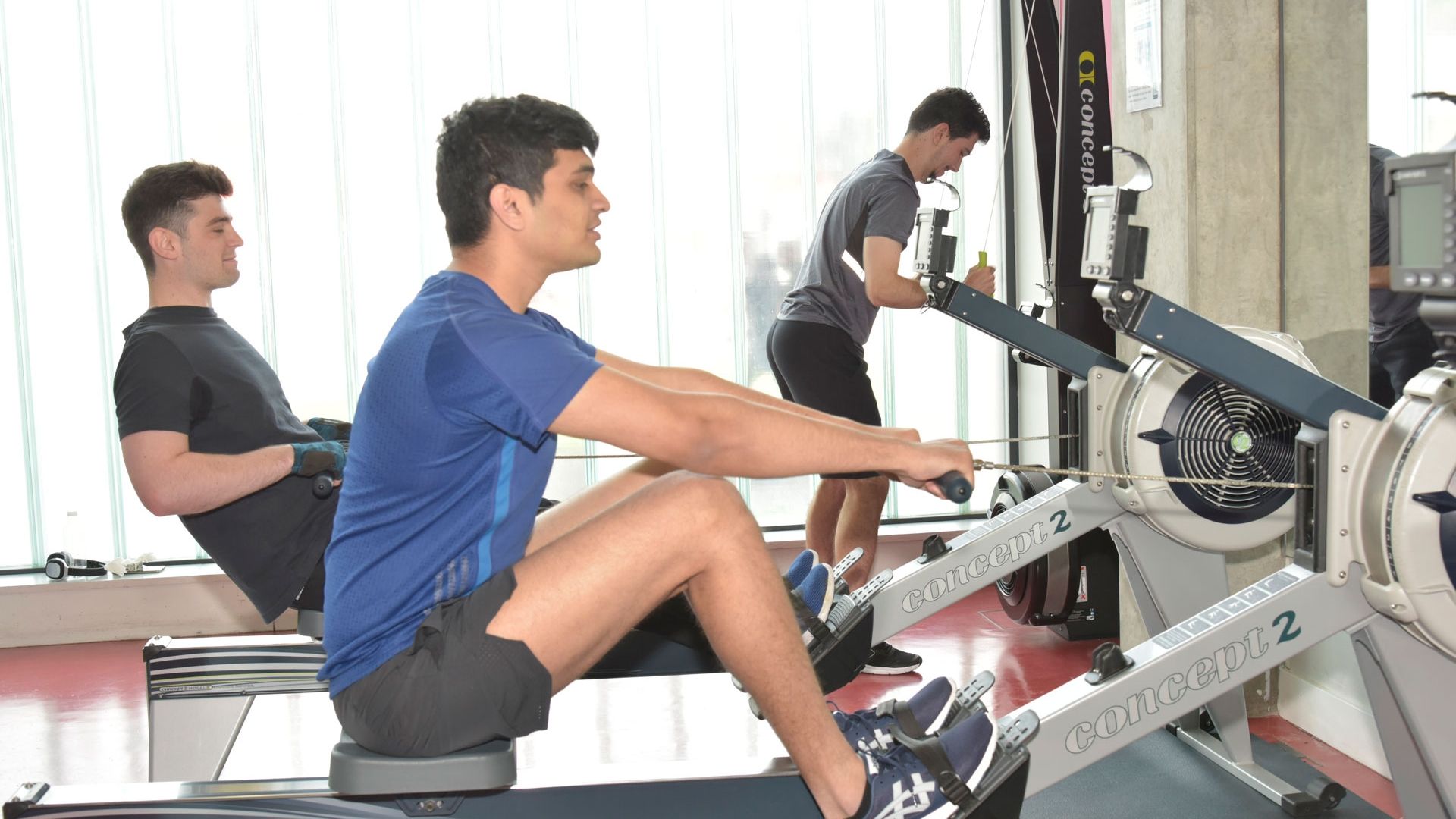 Gateway gym males on rowing machine 