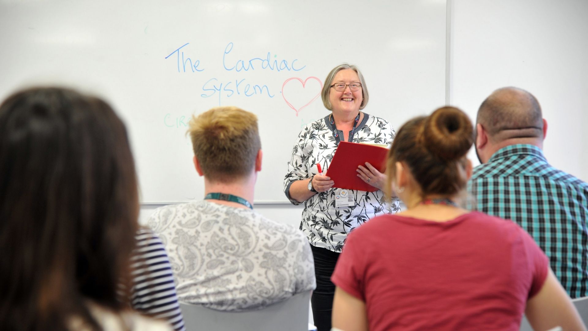 Nursing lecturer teaching a group of students