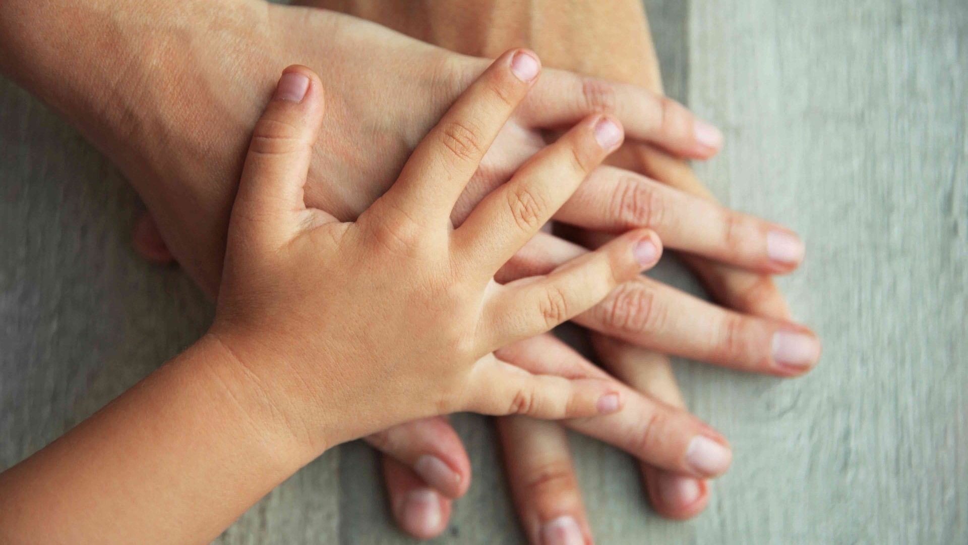 three white hands on top of each other