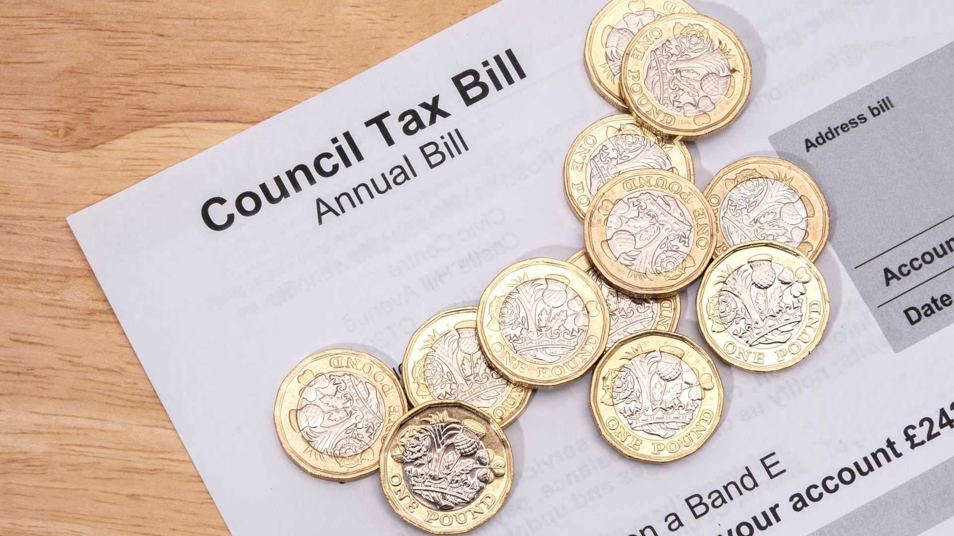 Council tax bill with £1 coins on