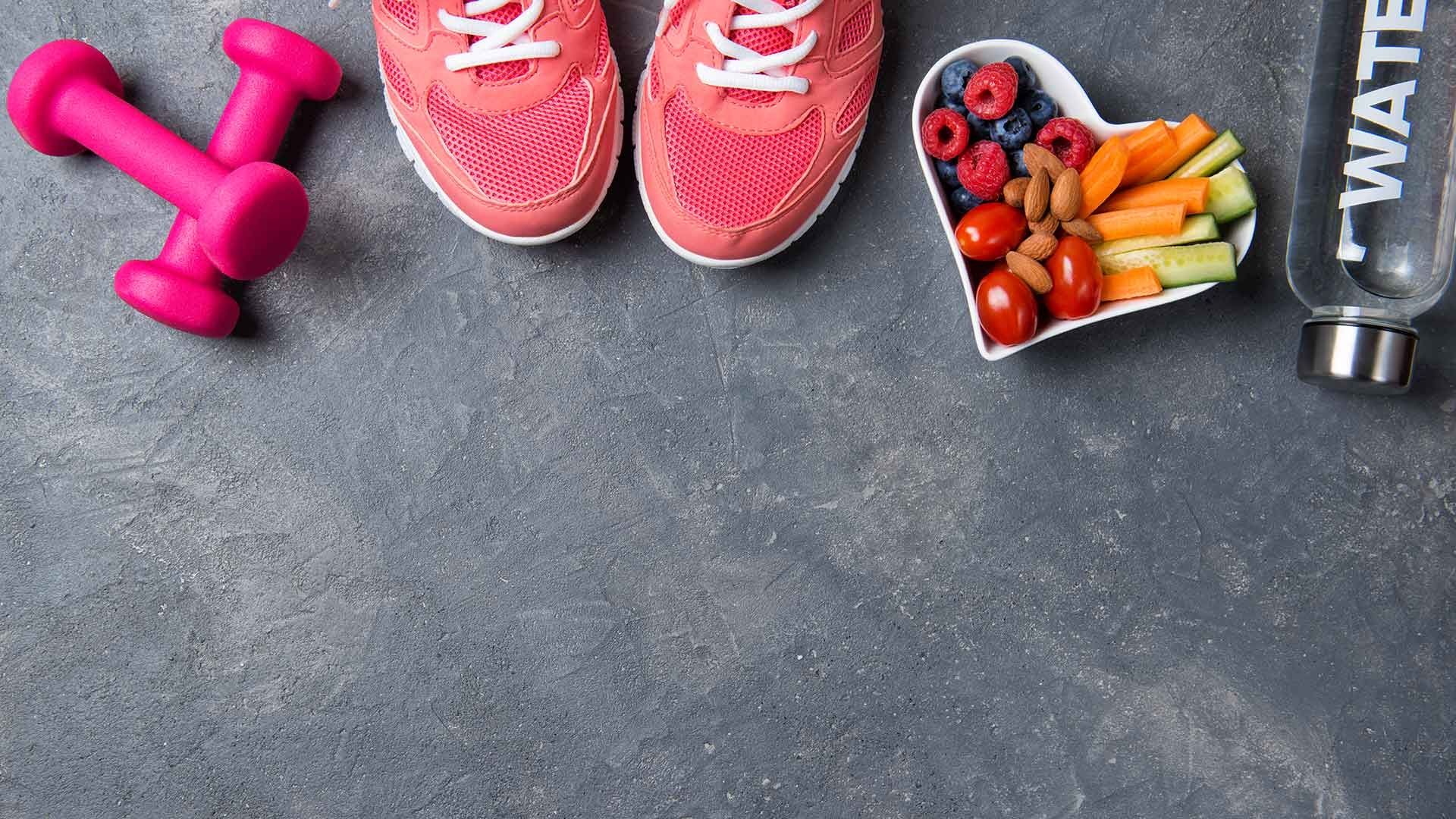 Living well image with weights fruit water and trainers