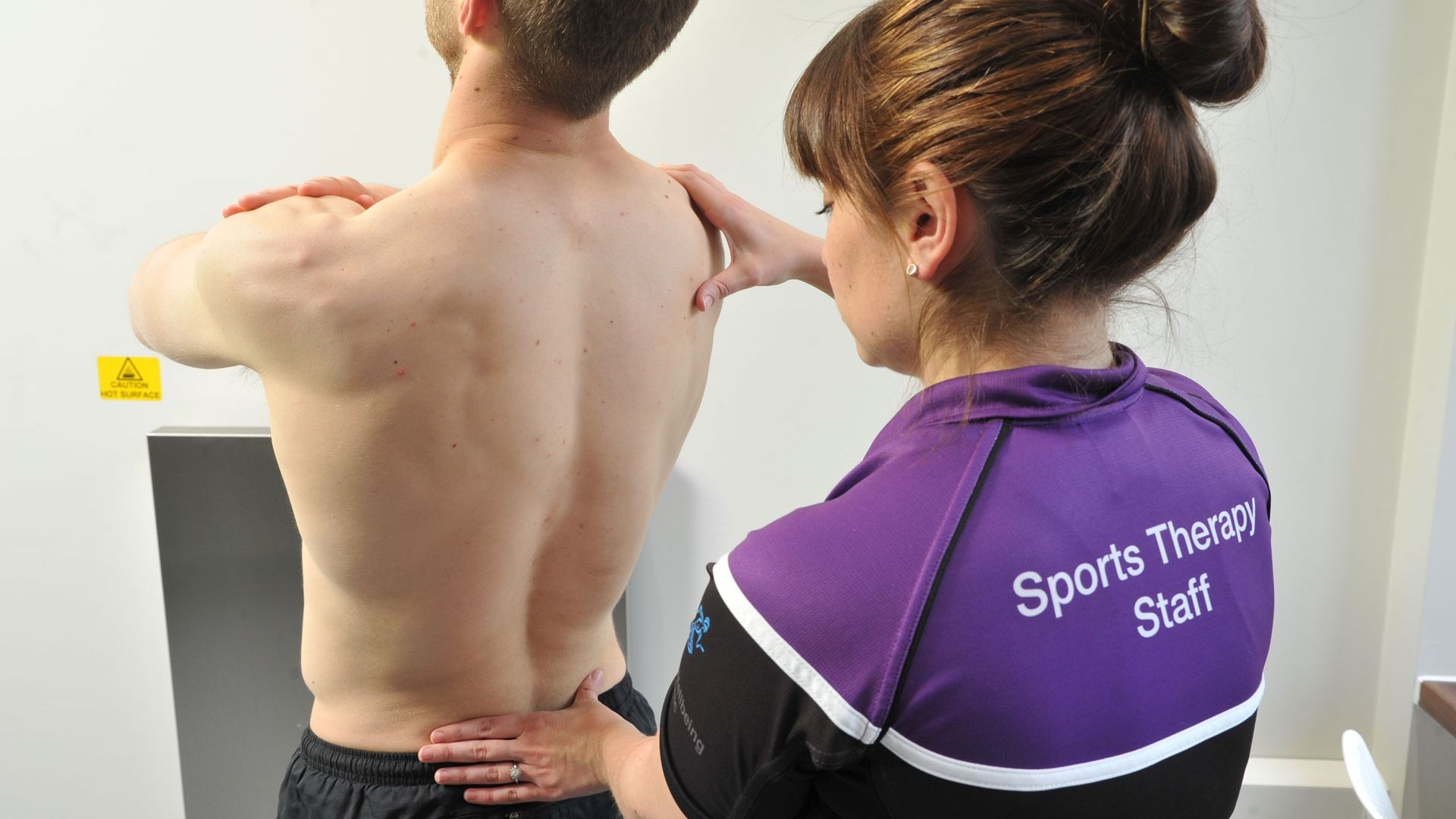 A sports therapy student attends to a male in the wellbeing clinic