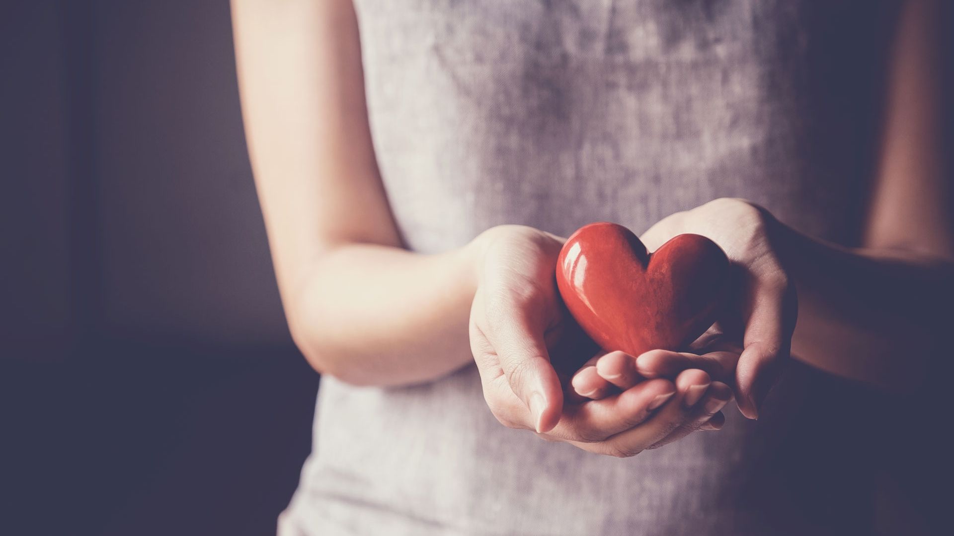 Female holding heart to show health and wellbeing