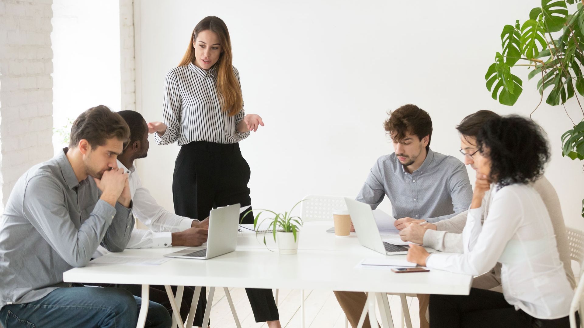business woman with colleagues in meeting room with laptops