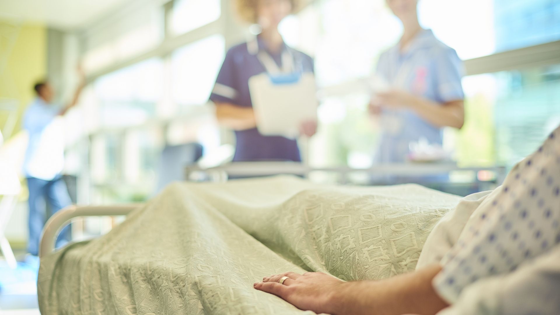 Clinical placements nurses stood next to patient in hospital bed