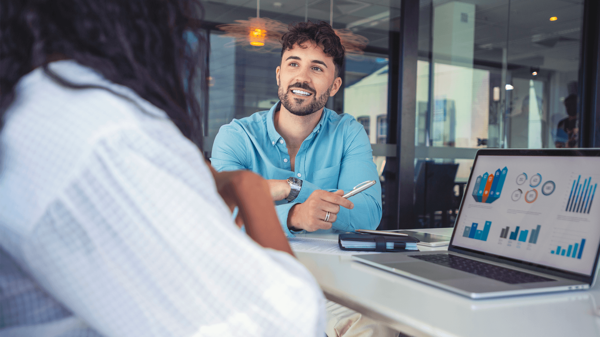 An accounting student in a meeting with another student whilst looking at data on a laptop