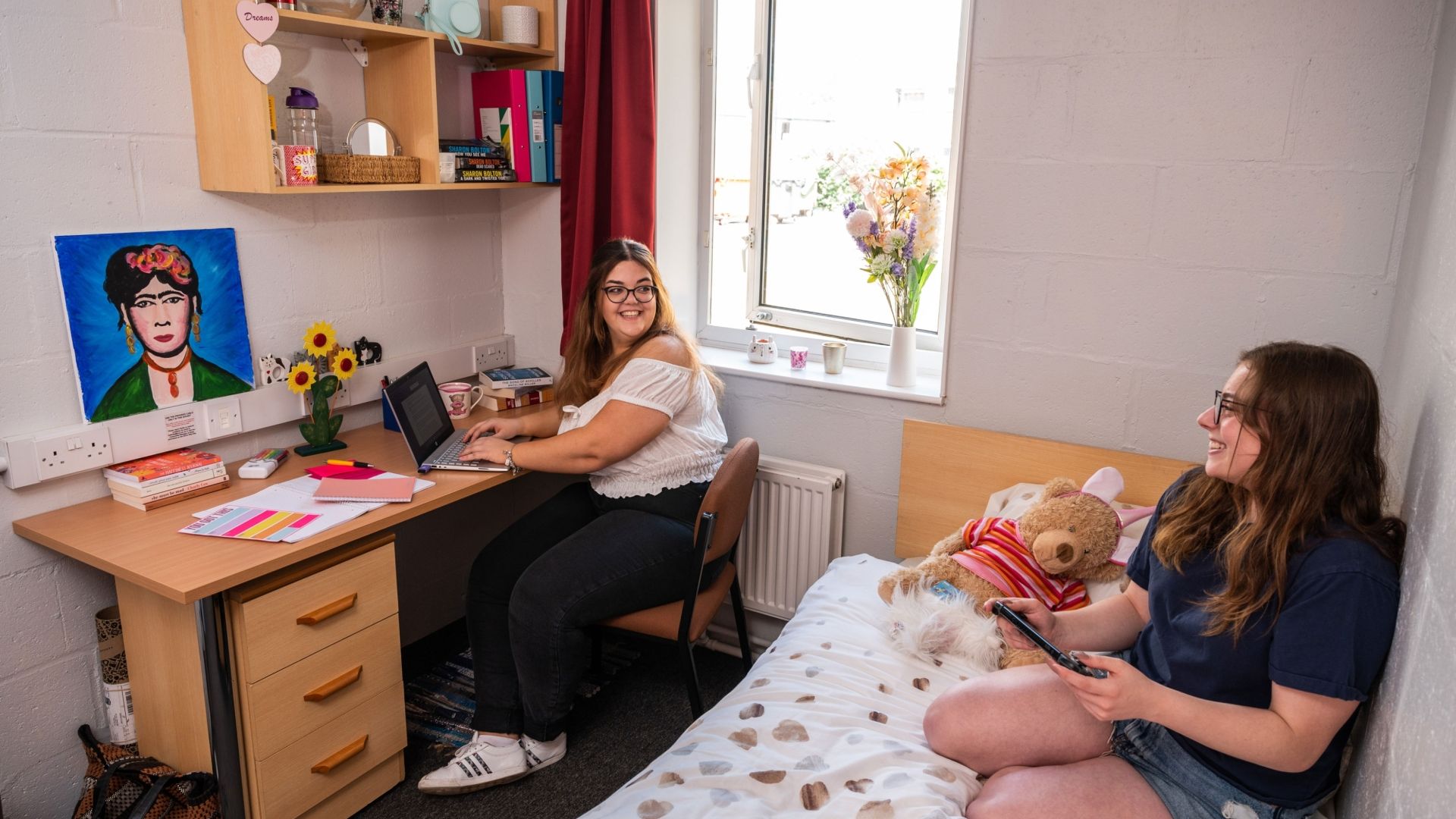 Two female students chatting in bedroom at Brook Street accommodation