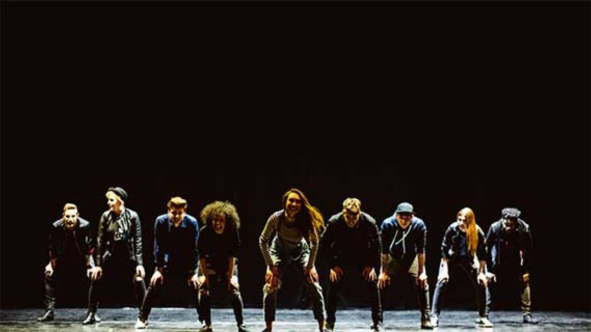 Musical Theatre students performing a dancing routine on stage under the spotlight