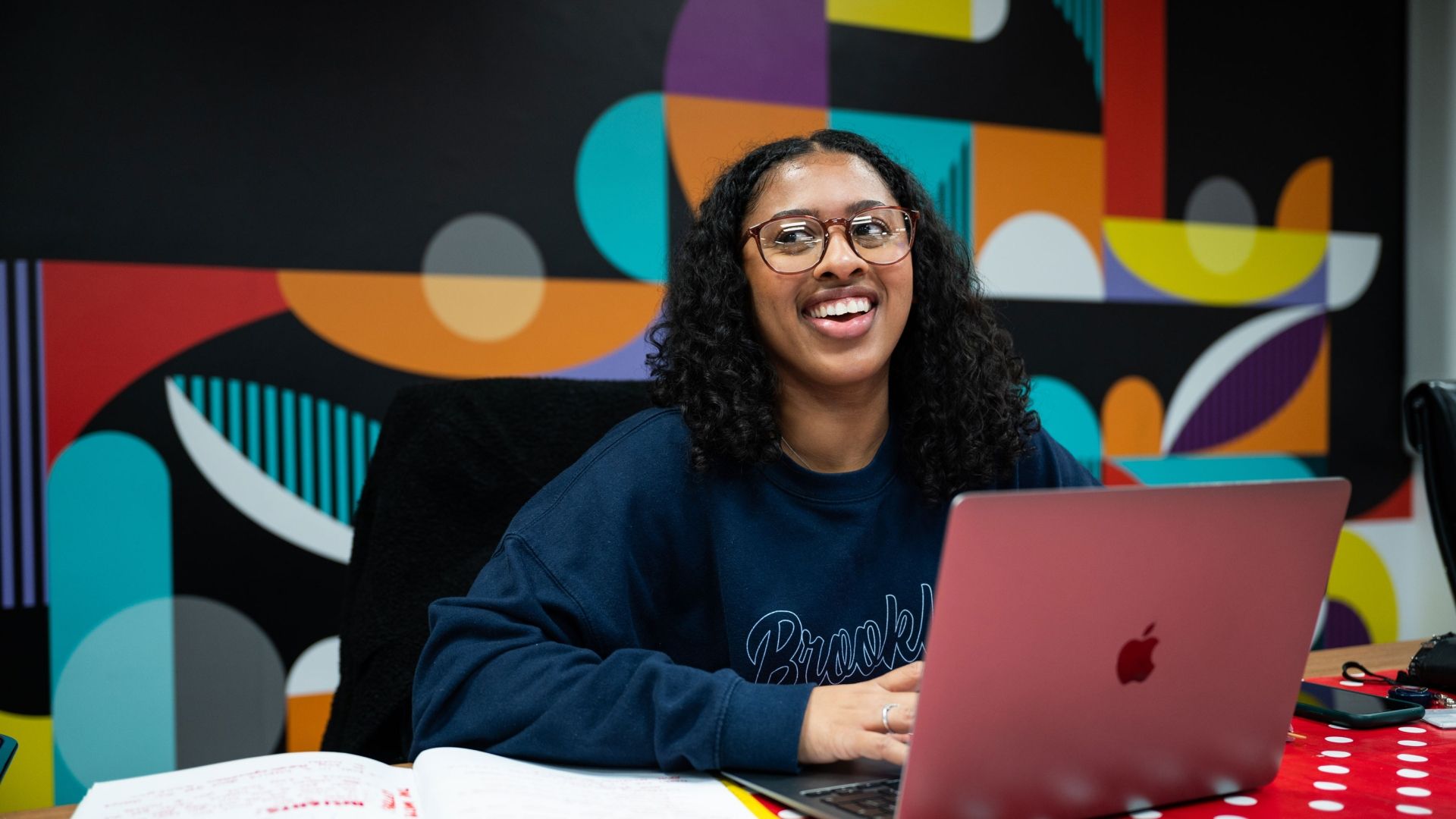 Creative Advertising student at laptop smiling