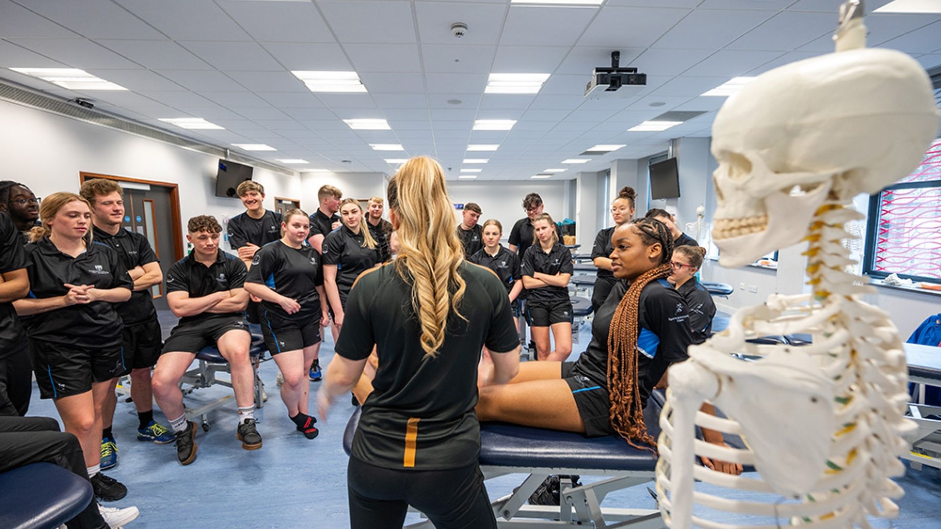 A Sports Therapy student lying down as a demonstration is given to the rest of the class.