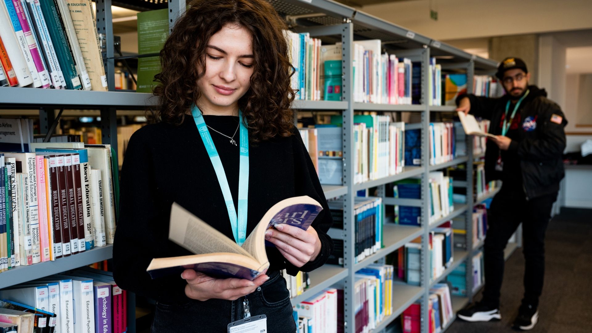 female student in library looking at books