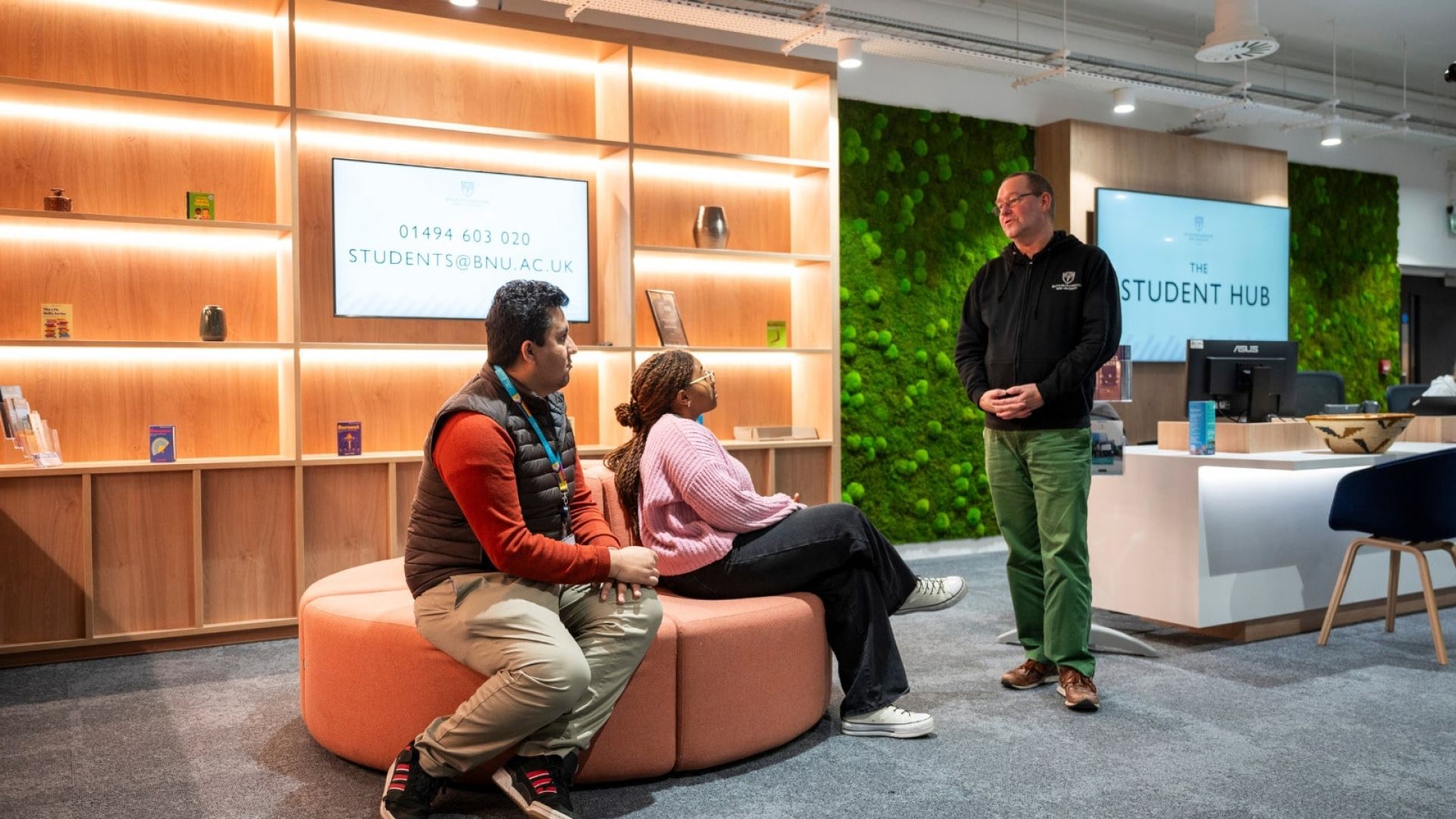 Two students sat down talking to a member of the Student Hub team.