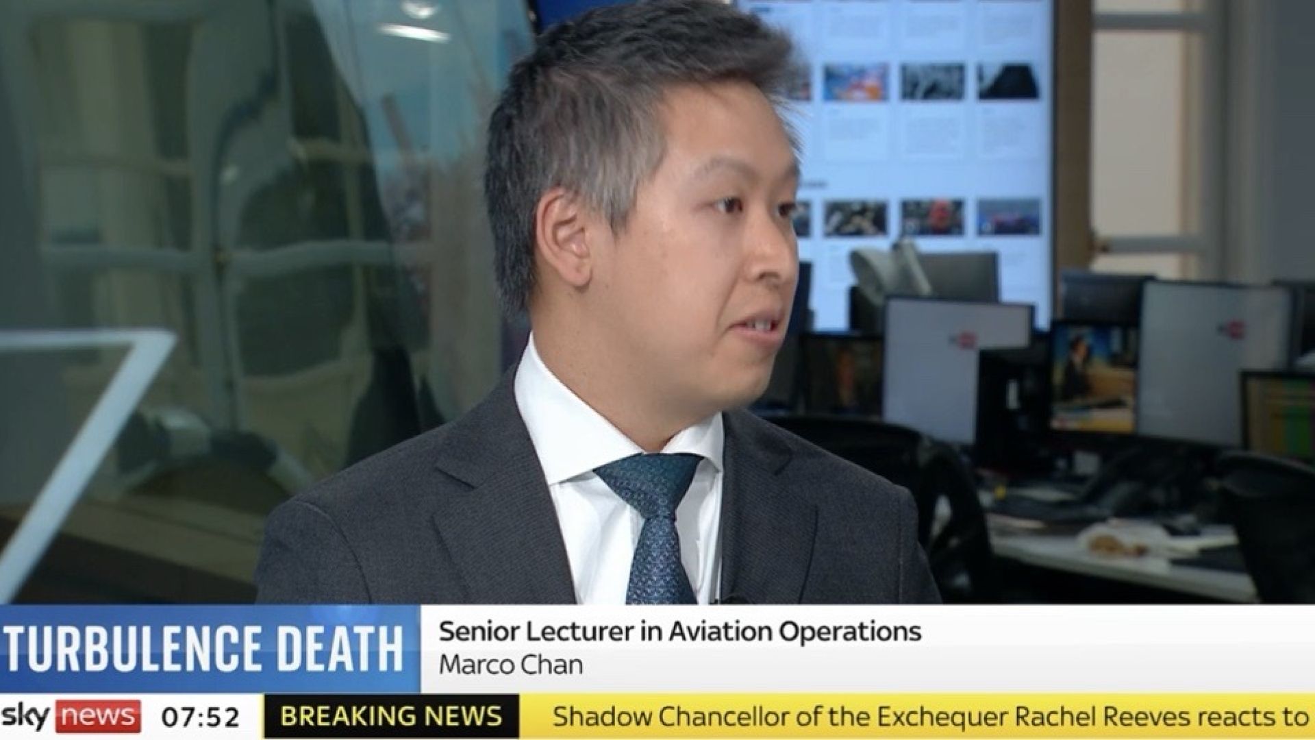 Man in a suit appearing on Sky News with his head turned as if talking to someone.