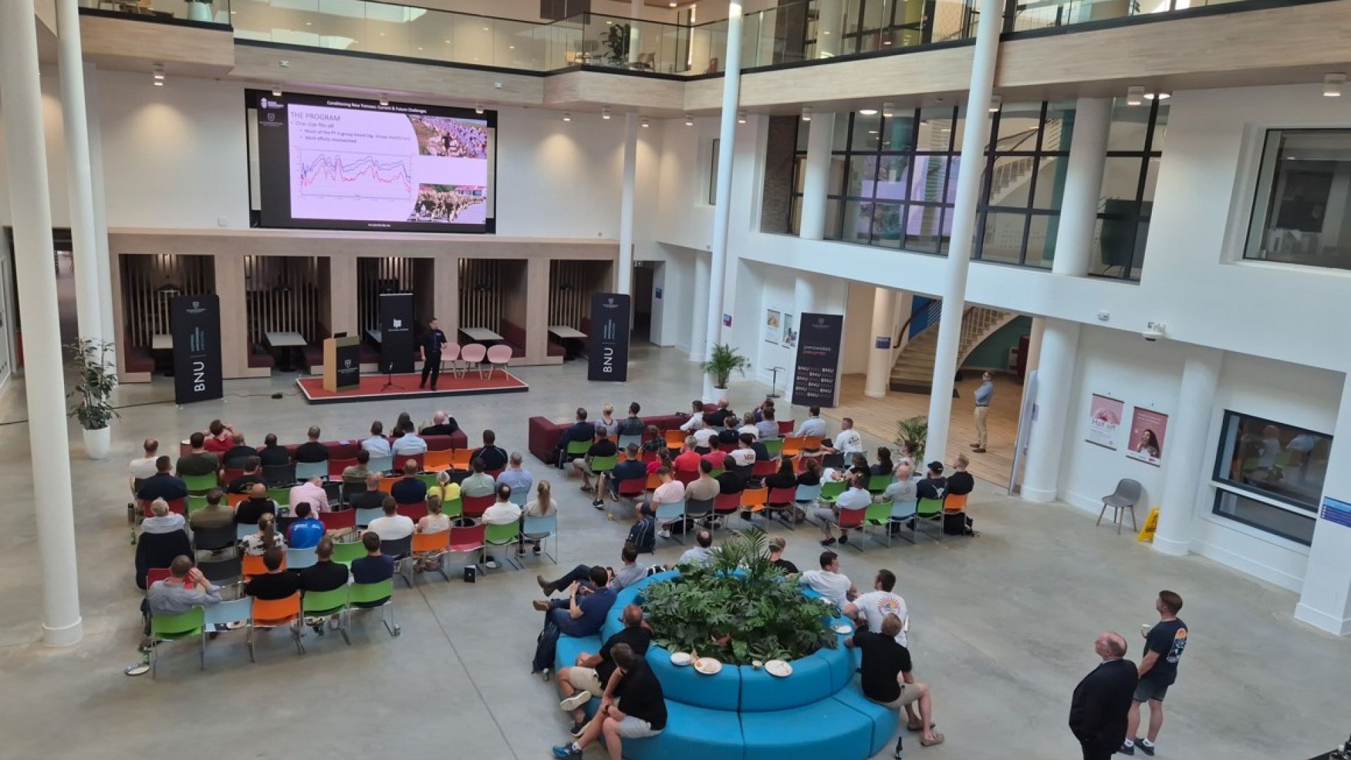 Room filled with people all sat around tables