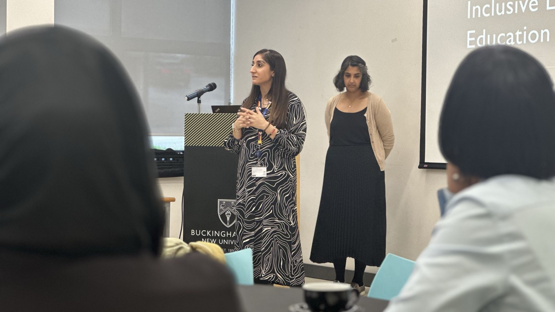 Zahara and Sanum stand at podium and address audience