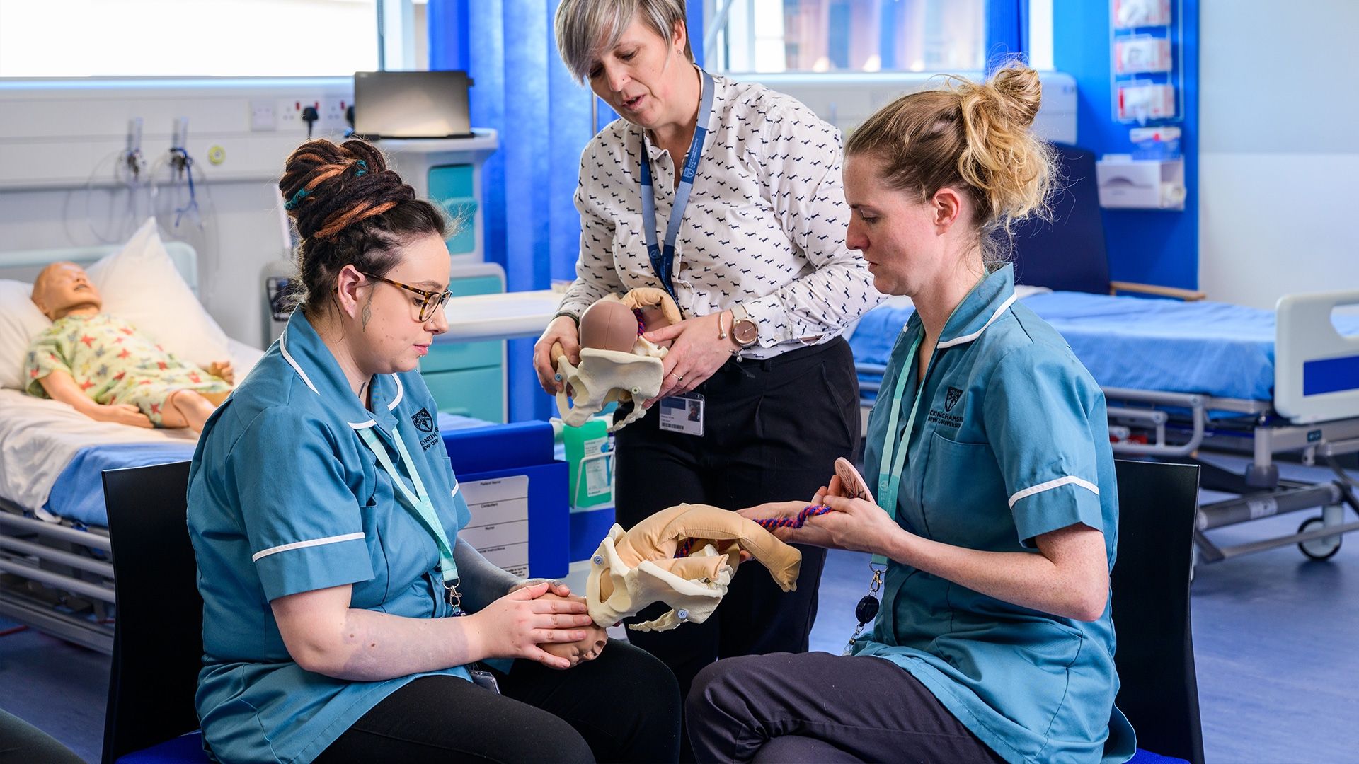 BNU Midwifery students working with a training mannequin in a simulation suite