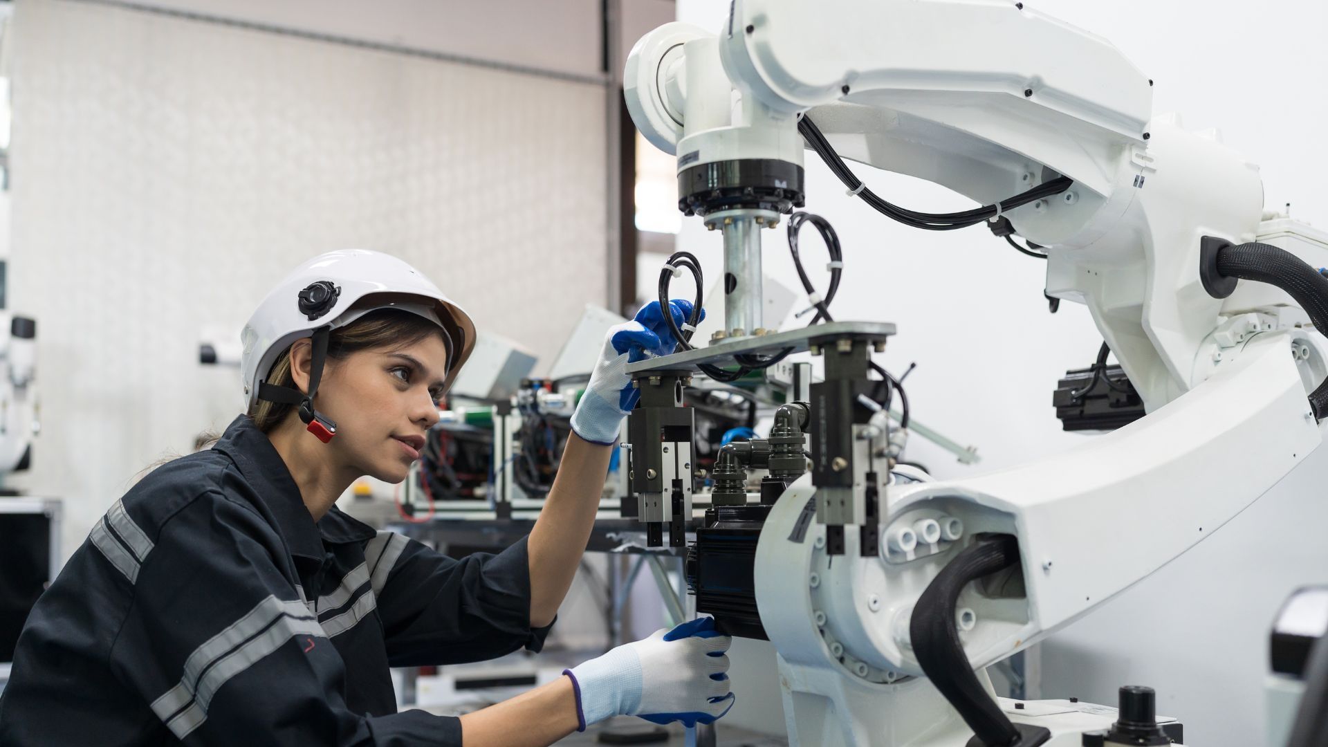 A student wearing a helment looking at a robot.