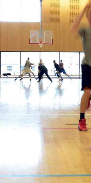 Buckinghamshire New University sports hall with two people playing basketball