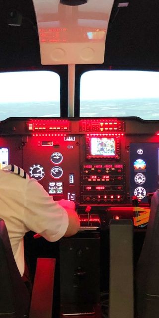 Student sat in a flight simulator cockpit looking at the controls