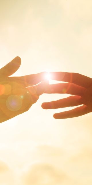 Two hands together infront of sun set