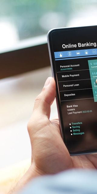 man using Online banking app on mobile phone while sitting down with coffee 