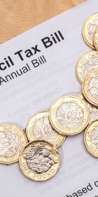 Council tax bill with £1 coins on
