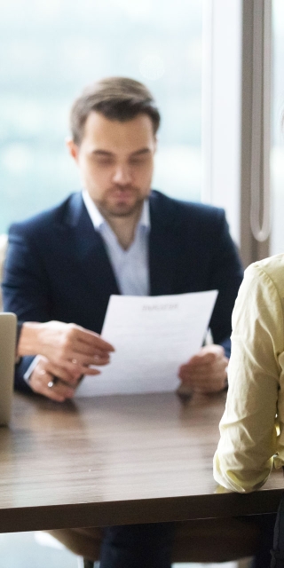Young adult being interviewed by two people in a private office