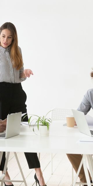 business woman with colleagues in meeting room with laptops