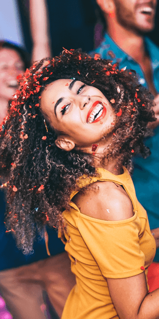 A woman dancing in a nightclub surrounded by four others also dancing to music
