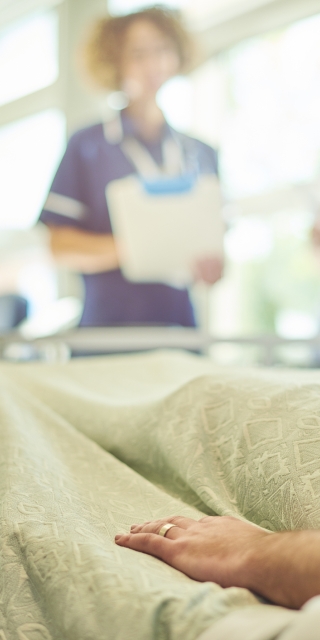 Clinical placements nurses stood next to patient in hospital bed