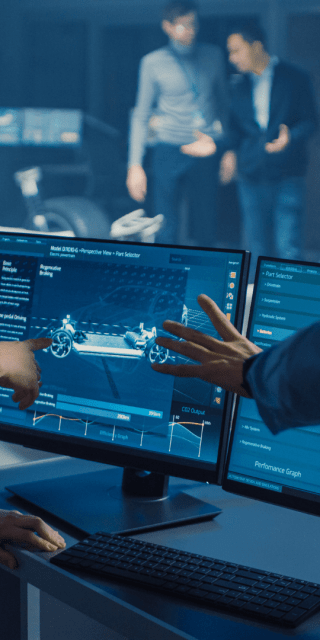 Two students pointing and looking at a computer screen which has digital drawings on.