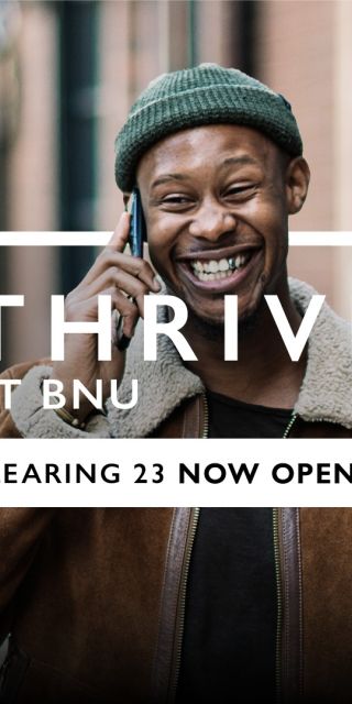 A man with a phone held to his ear smiling as he walks along a street with the text "Thrive at BNU, Clearing 23 now open" over the top.