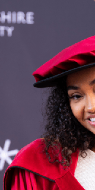 Leigh-Anne smiling whilst wearing Graduation attire.