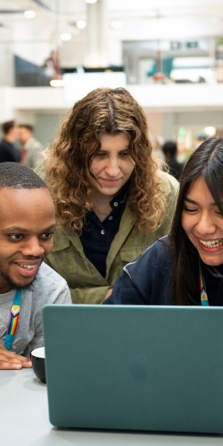 Students gathered together around a laptop