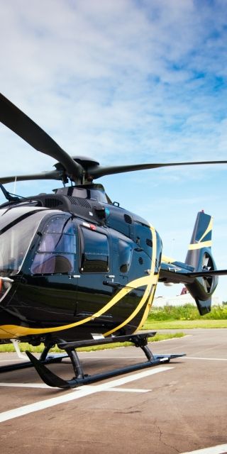 A black helicopter on a landing pad