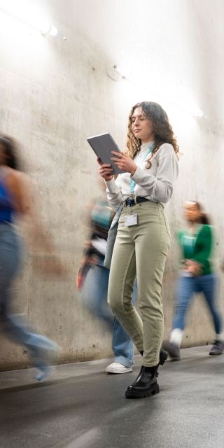 Students walking past concrete wall in gateway