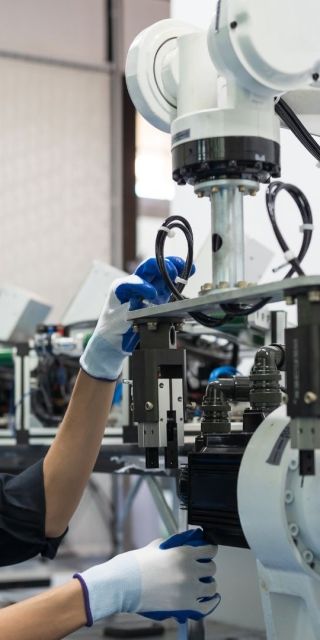 A student wearing a helment looking at a robot.
