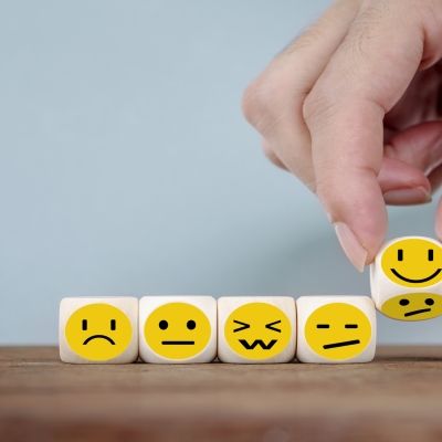 six mini cubes with different emoji face expressions on, all lined up together