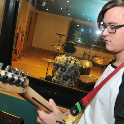Two Bucks music students recording guitar and drums in the studio