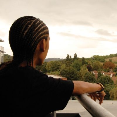 Bucks student standing on balcony of student halls looking over fields