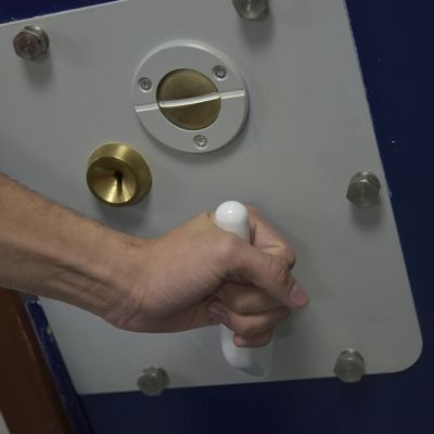A police cell door handle being turned closed