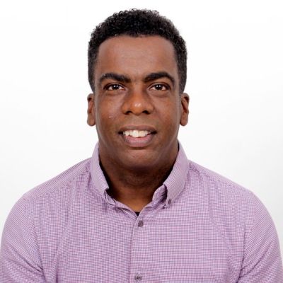 Head and shoulders shot of a smiling Earlroy Edwards wearing a purple shirt
