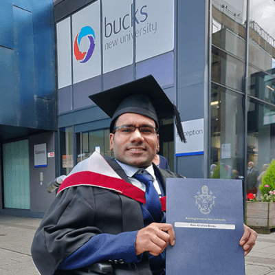 Ram on graduation day holding up his certificates