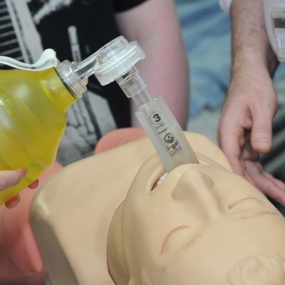 Nursing students attend to a dummy person, giving them oxygen 