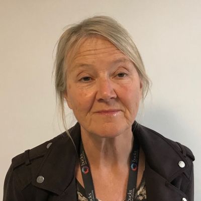 A head and shoulders shot of a smiling Maria Ansbro who is wearing a black coat with the BNU land yard around her neck whilst looking directly into the camera