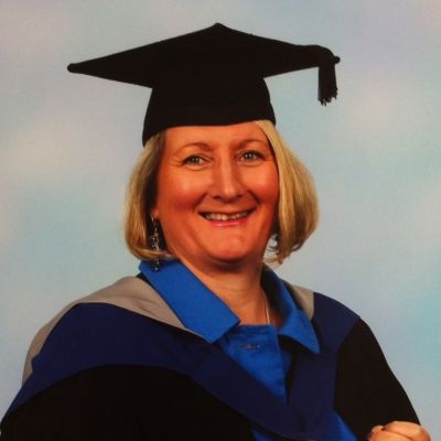 A head and shoulders shot of Natasha Loughrey wearing her graduation hat and gown stood face on and looking directly into the camera